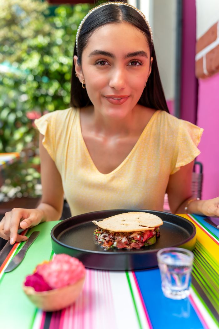 Woman enjoys Mexican food at a colorful restaurant in CDMX, Mexico.